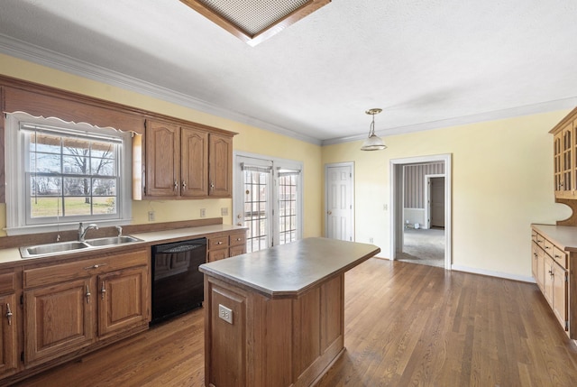 kitchen with black dishwasher, a kitchen island, plenty of natural light, and a sink