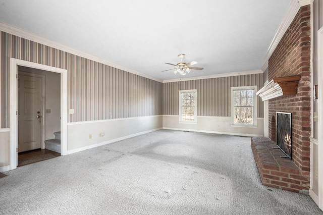 unfurnished living room featuring carpet floors, a brick fireplace, ornamental molding, and baseboards