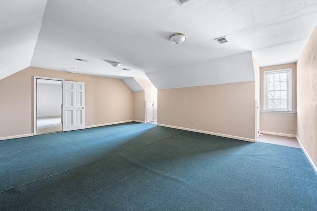 bonus room featuring vaulted ceiling, visible vents, dark carpet, and baseboards