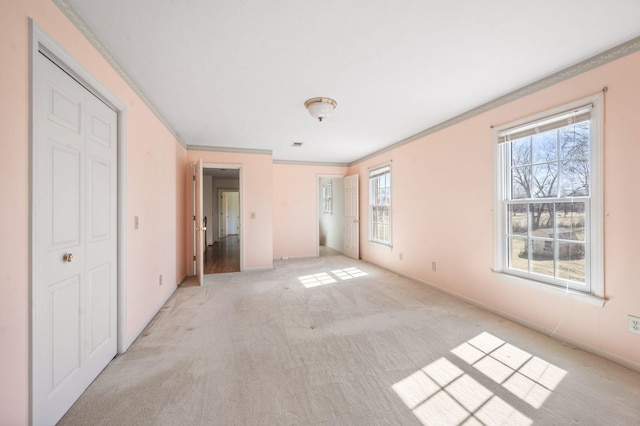 unfurnished bedroom with light carpet, baseboards, and crown molding