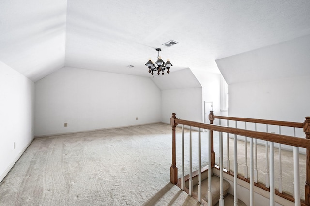 bonus room with carpet, lofted ceiling, visible vents, baseboard heating, and an inviting chandelier