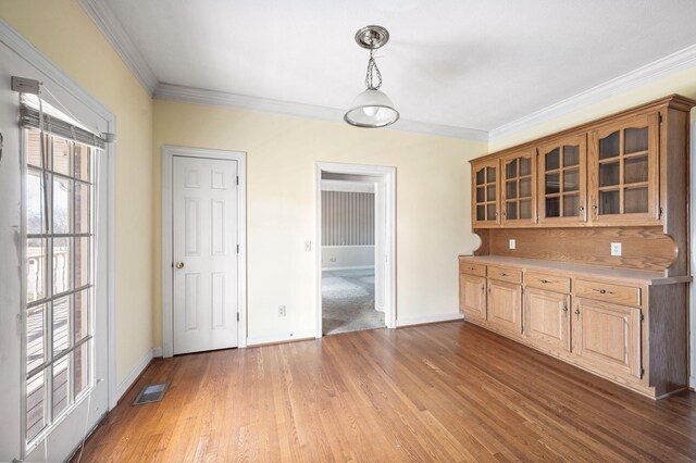 kitchen with glass insert cabinets, light countertops, visible vents, and wood finished floors