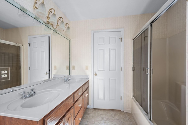 full bath with double vanity, a sink, and wallpapered walls