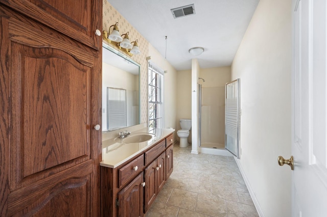 bathroom with toilet, vanity, visible vents, baseboards, and a stall shower