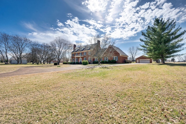 exterior space featuring a garage, a chimney, and a front yard