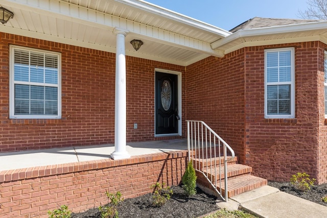 doorway to property featuring brick siding