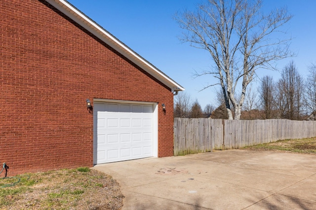 garage featuring fence and driveway