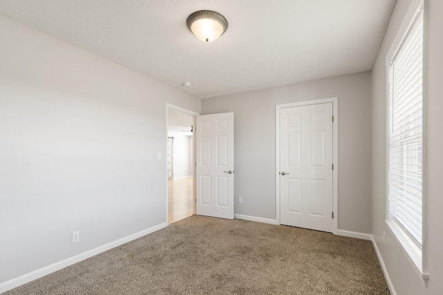 unfurnished bedroom featuring carpet floors and baseboards