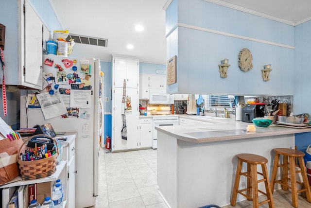 kitchen with white appliances, visible vents, a peninsula, white cabinetry, and a sink