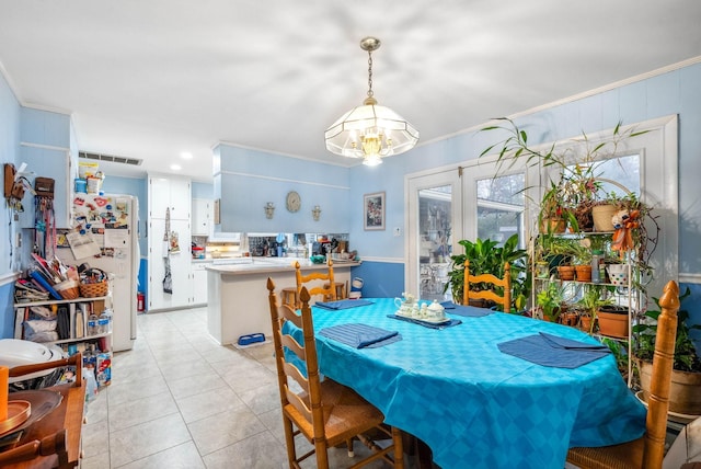 dining area with ornamental molding, light tile patterned flooring, visible vents, and an inviting chandelier