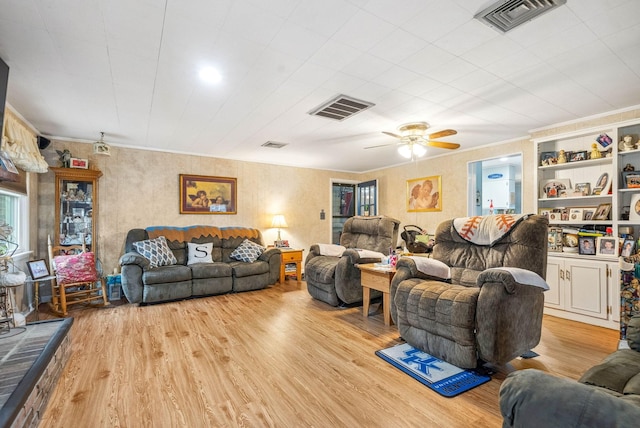 living area featuring ornamental molding, visible vents, and light wood-style flooring