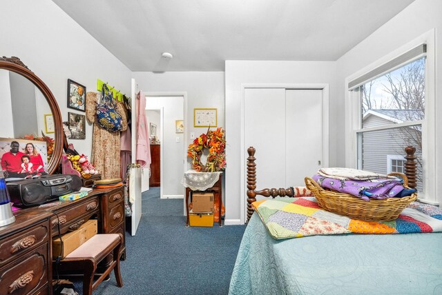 carpeted bedroom with a closet and baseboards