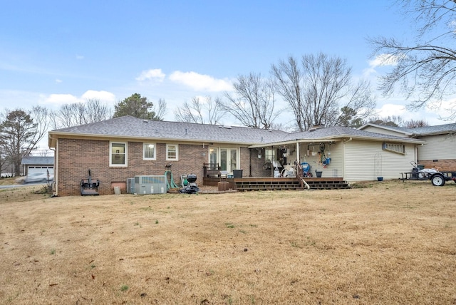 rear view of house with central AC, french doors, a lawn, and brick siding