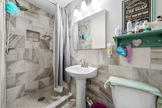 full bath featuring tile walls, backsplash, toilet, a sink, and a shower stall