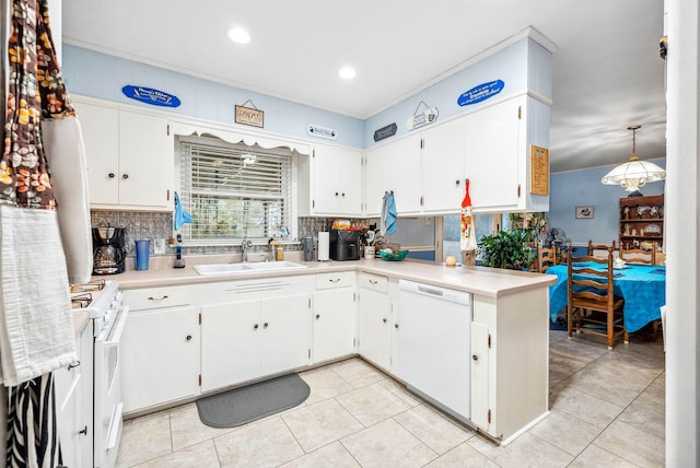 kitchen with light countertops, white appliances, a sink, and decorative backsplash