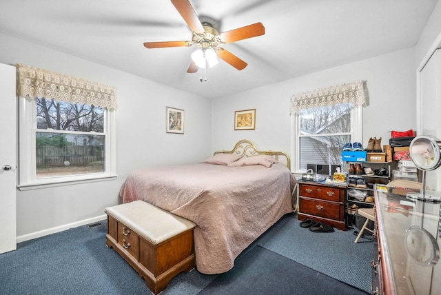 bedroom featuring baseboards, visible vents, dark carpet, and a ceiling fan