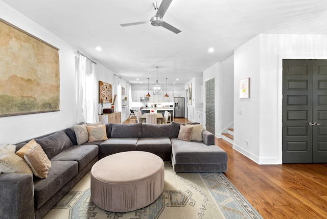 living area featuring a ceiling fan, recessed lighting, baseboards, and wood finished floors