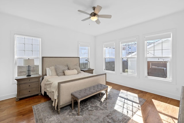 bedroom featuring ceiling fan, baseboards, and wood finished floors