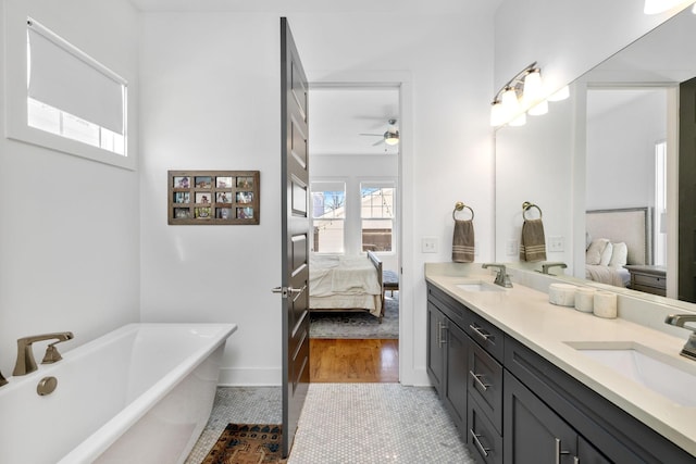 full bathroom featuring a sink, a freestanding bath, ensuite bath, and double vanity