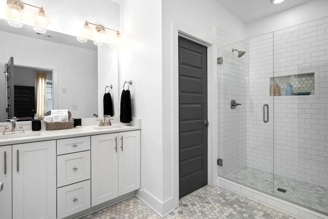 bathroom featuring tile patterned flooring, a sink, a shower stall, and double vanity