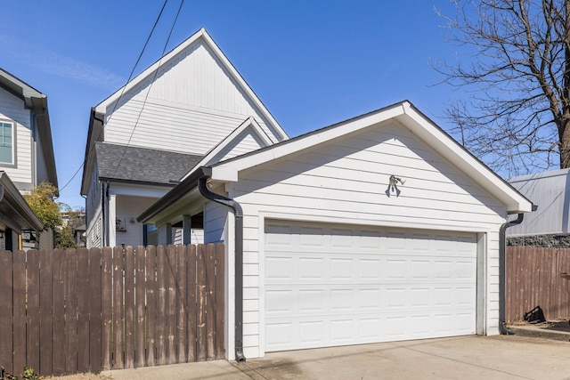 view of front of home featuring an attached garage, fence, and roof with shingles