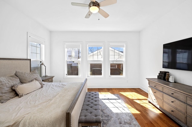 bedroom with ceiling fan, light wood finished floors, and baseboards