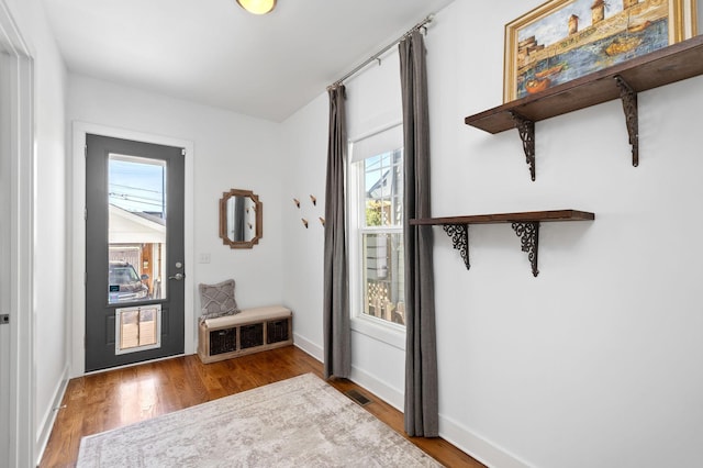 entryway featuring visible vents, baseboards, and wood finished floors