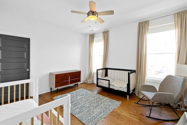 bedroom with a ceiling fan, baseboards, and wood finished floors