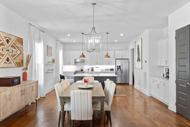 dining space with dark wood-style floors, recessed lighting, and an inviting chandelier