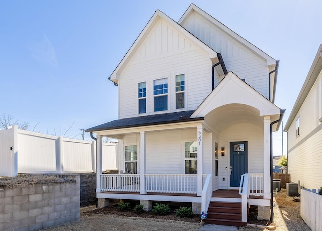 view of front of house featuring central AC unit, covered porch, a shingled roof, fence, and board and batten siding