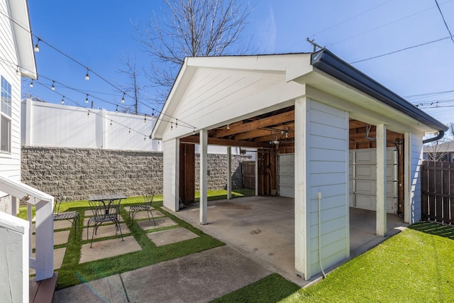 view of patio / terrace featuring fence and an outbuilding