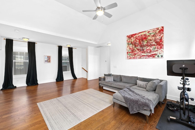 living area featuring lofted ceiling, ceiling fan, baseboards, and wood finished floors