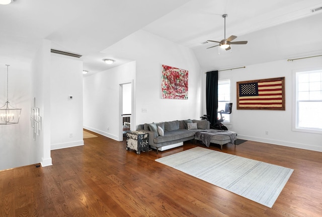 living area with lofted ceiling, wood finished floors, visible vents, and baseboards