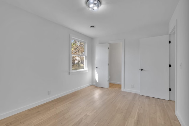 unfurnished bedroom with baseboards, visible vents, and light wood-style floors