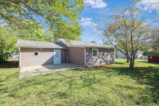 rear view of property featuring a yard and a patio