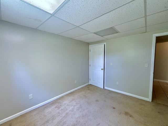 unfurnished room featuring a paneled ceiling, baseboards, and carpet flooring