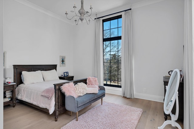 bedroom with baseboards, multiple windows, ornamental molding, and wood finished floors