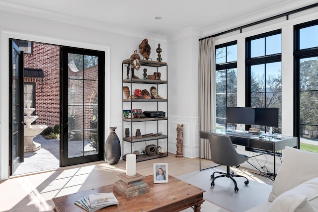 office area featuring a wainscoted wall, ornamental molding, and wood finished floors