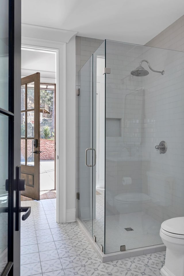 full bath featuring french doors, a shower stall, and toilet