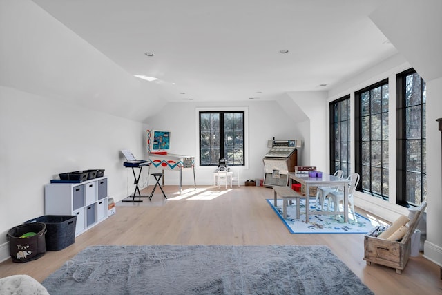 interior space featuring lofted ceiling, baseboards, and wood finished floors