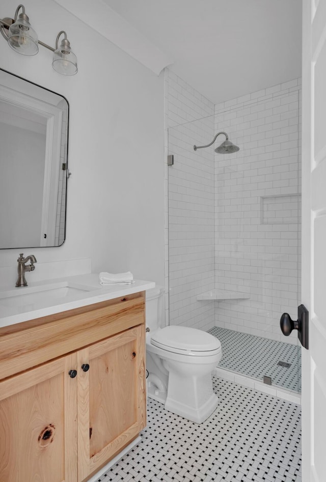 full bathroom with toilet, a stall shower, and vanity