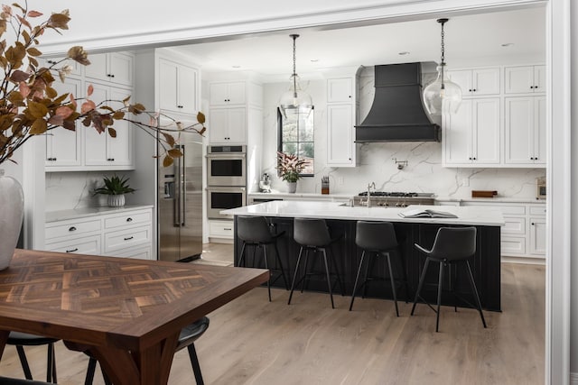 kitchen featuring stainless steel appliances, light countertops, custom range hood, and a kitchen breakfast bar