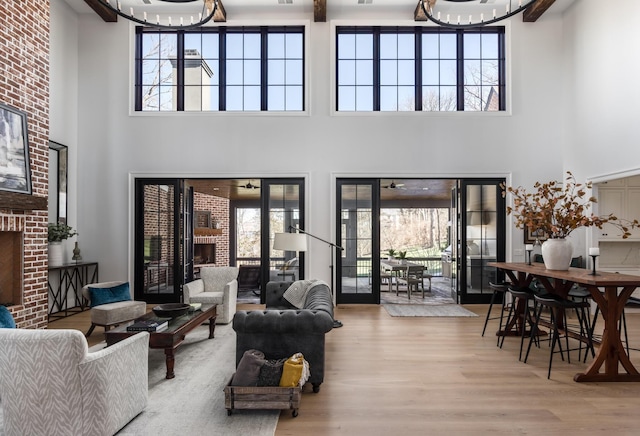 living room with a healthy amount of sunlight, a brick fireplace, and wood finished floors