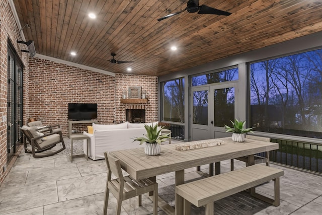 sunroom featuring wood ceiling and a ceiling fan