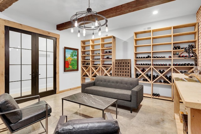 wine room with a chandelier, baseboards, finished concrete flooring, french doors, and beamed ceiling