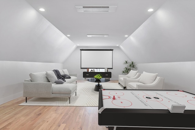 home theater featuring lofted ceiling, recessed lighting, visible vents, wood finished floors, and baseboards