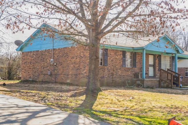 view of side of property featuring brick siding and a lawn