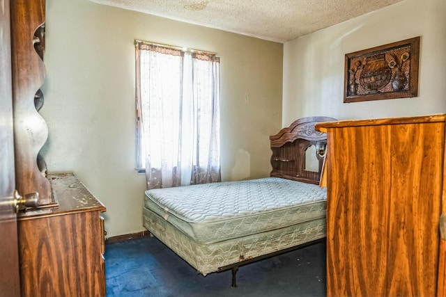 bedroom with dark carpet and a textured ceiling