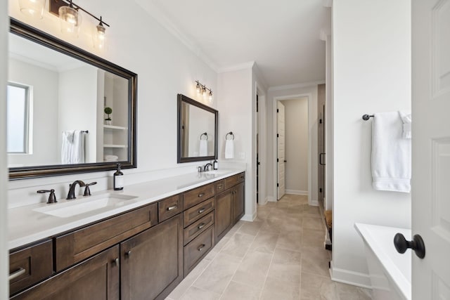 full bath featuring ornamental molding, a bathtub, a sink, and double vanity