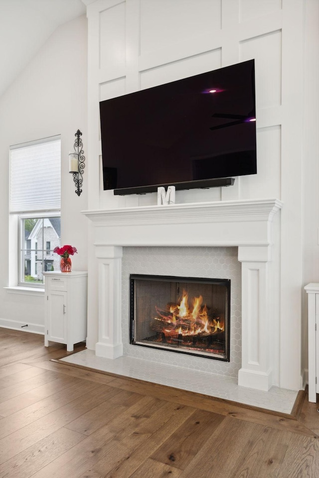 details featuring a fireplace with flush hearth and wood finished floors